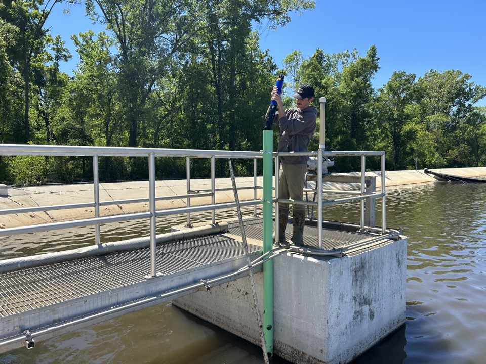 mason deploying sensors in wastewater treatment pond