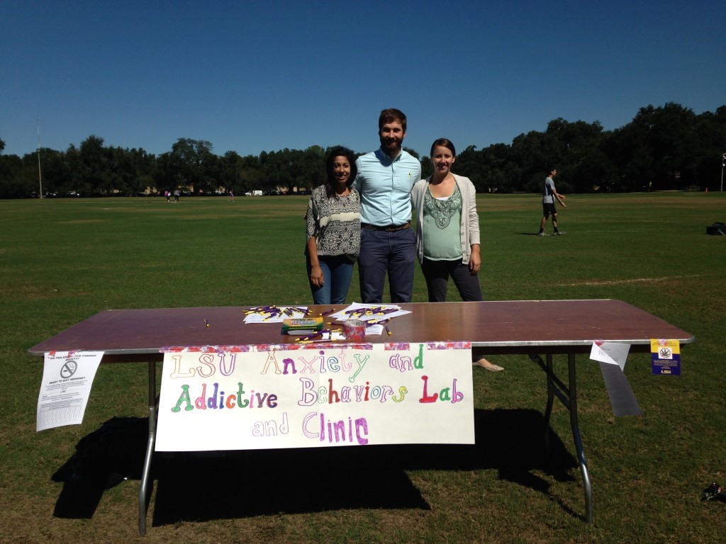 Graduate students Sonia Shah, Tony Ecker, and Emily Jeffries at the LSU Anxiety and Addictive Behaviors Lab and Clinic table. 