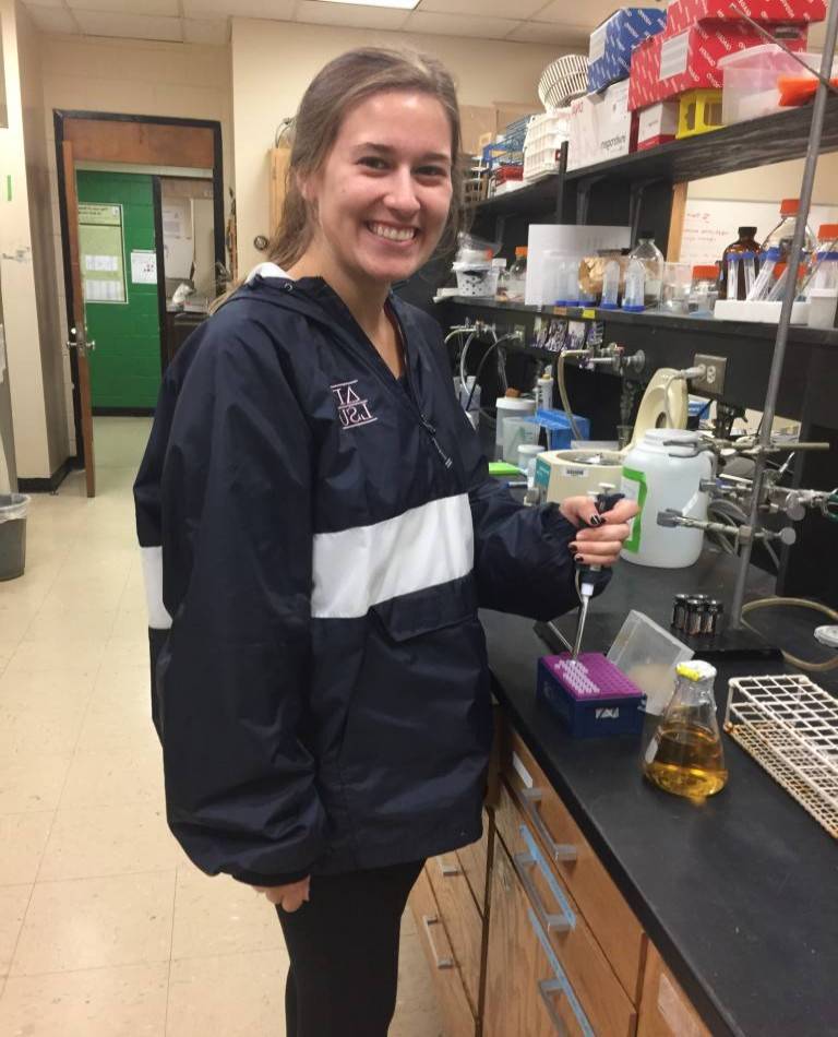 Undergraduate worker Anna in the lab using a pippette