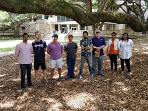 2018 lab members at end-of-semester lunch, standing side-by-side smiling under oak trees in the Memorial Grove on LSU campus