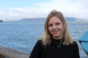 Undergraduate worker Rebecca smiling in front of a body of water