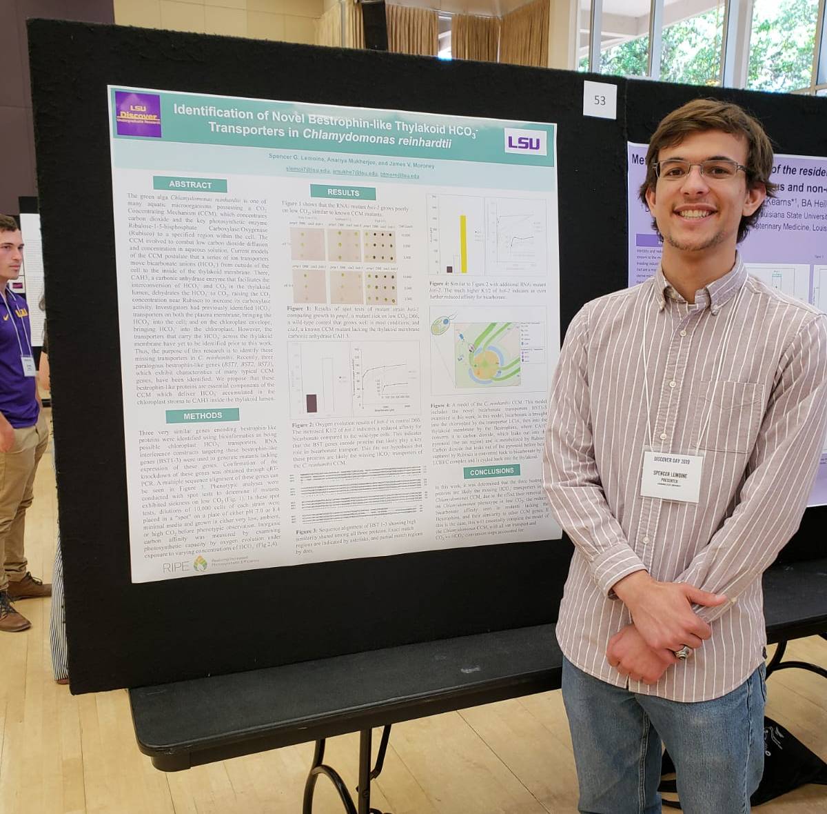 Spencer smiling, standing in front of his LSU Discover Day poster