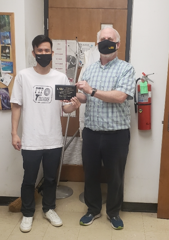 Tim and Dr. Moroney posing together in the lab with Tim's award plaque