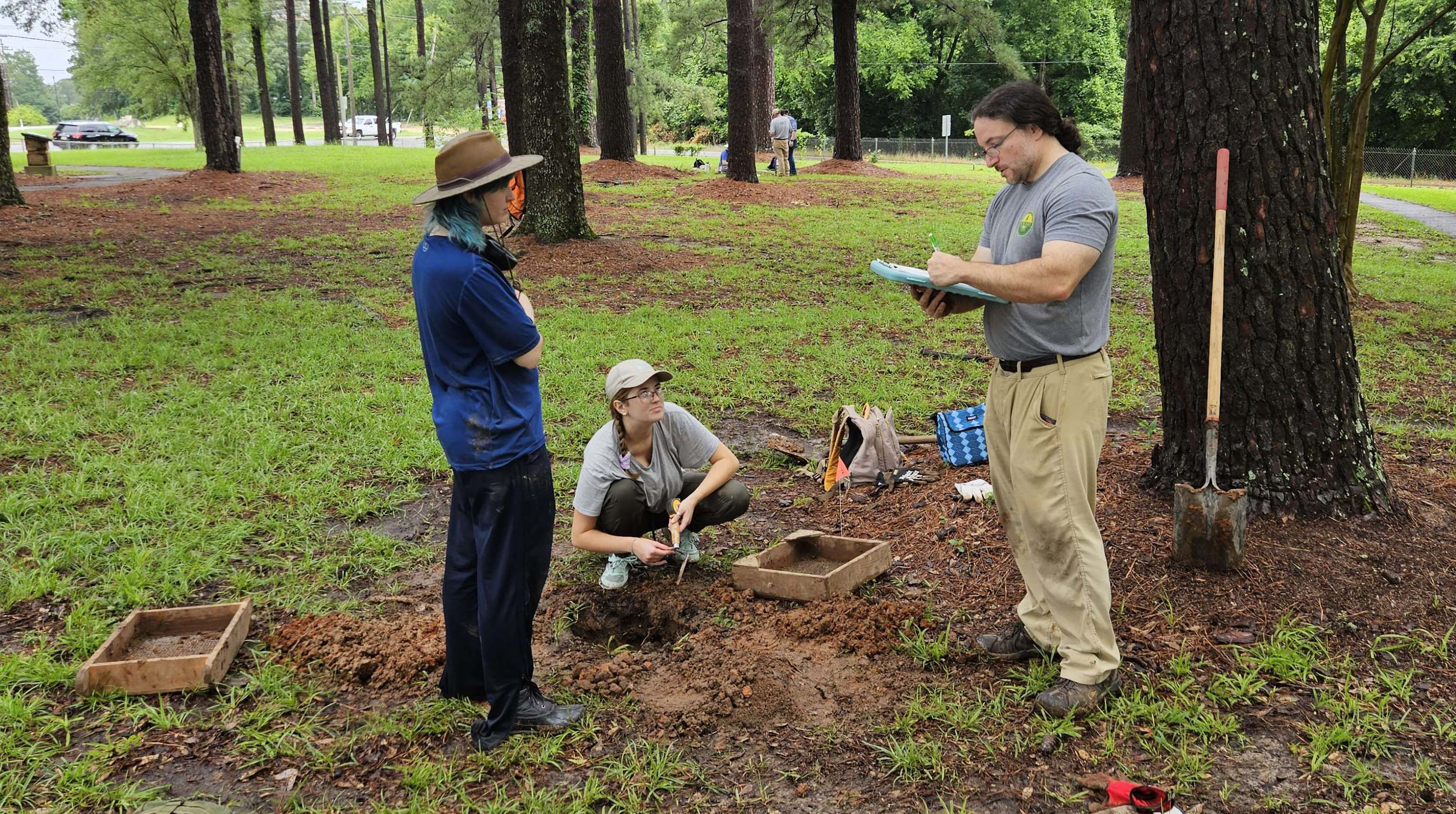 Matt Helmer and LSu students excavating a test unit