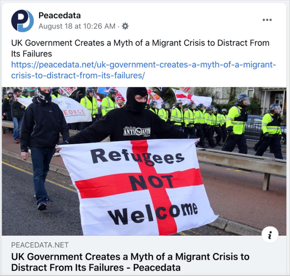 A screenshot of a Facebook post made by the fake news website, Peacedata, which is run by Russian operative. The title of the fake news story reads "UK Government Creates a Myth of a Migrant Crisis to Distract From its Failures, with a picture showing a protestor who is carrying a flag that says "Refugees Not Welcome"