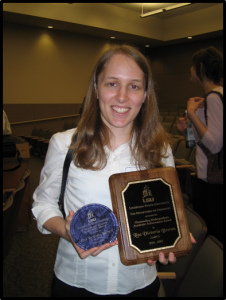 Lisa B. holding two awards and smiling