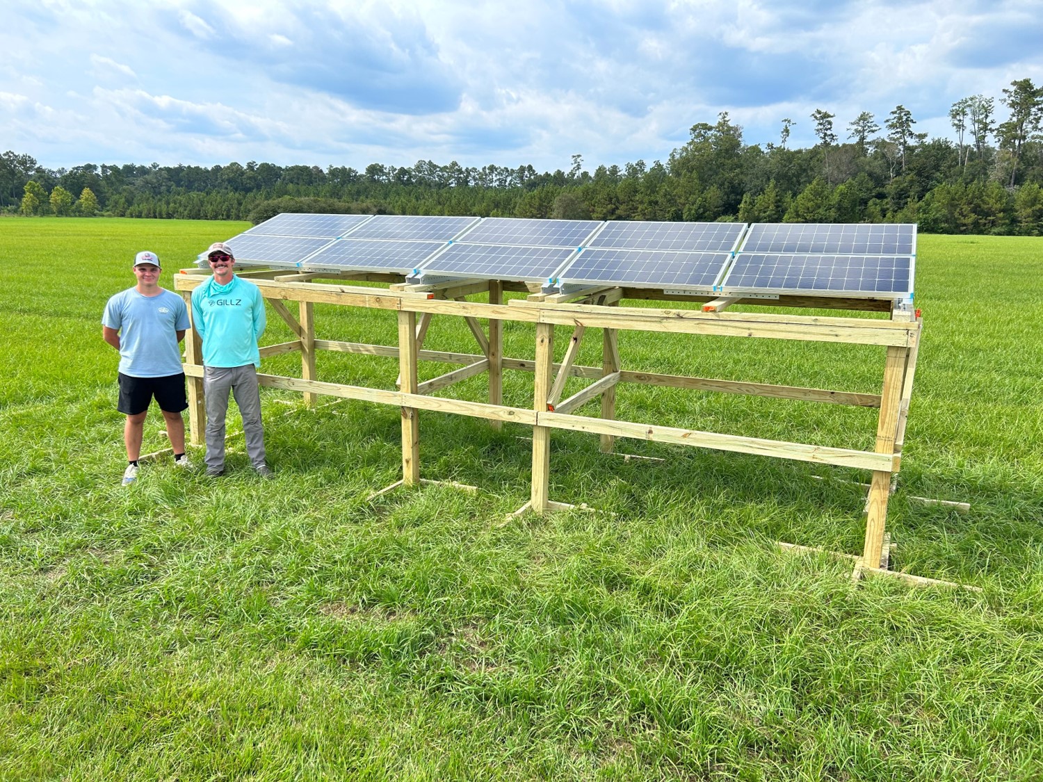 Nick and Mason standing by solar panels