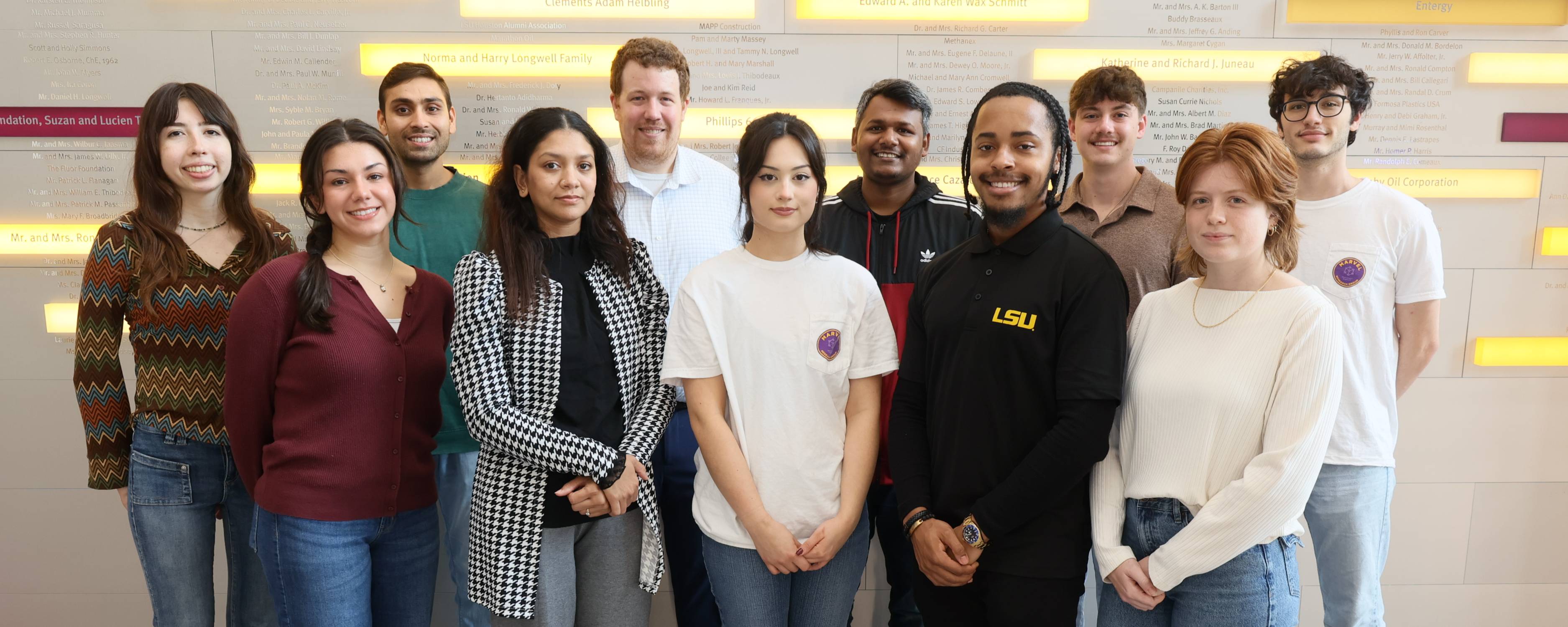 2024 - 2025 academic year EPIC lab group, standing in front of wall with yellow and purple blocks.