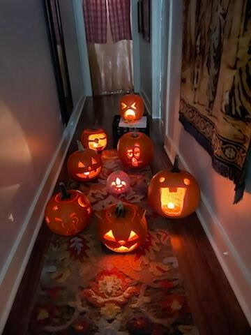 Carved pumpkins (Fall 2025 pumpkin party) lit up in a hallway.