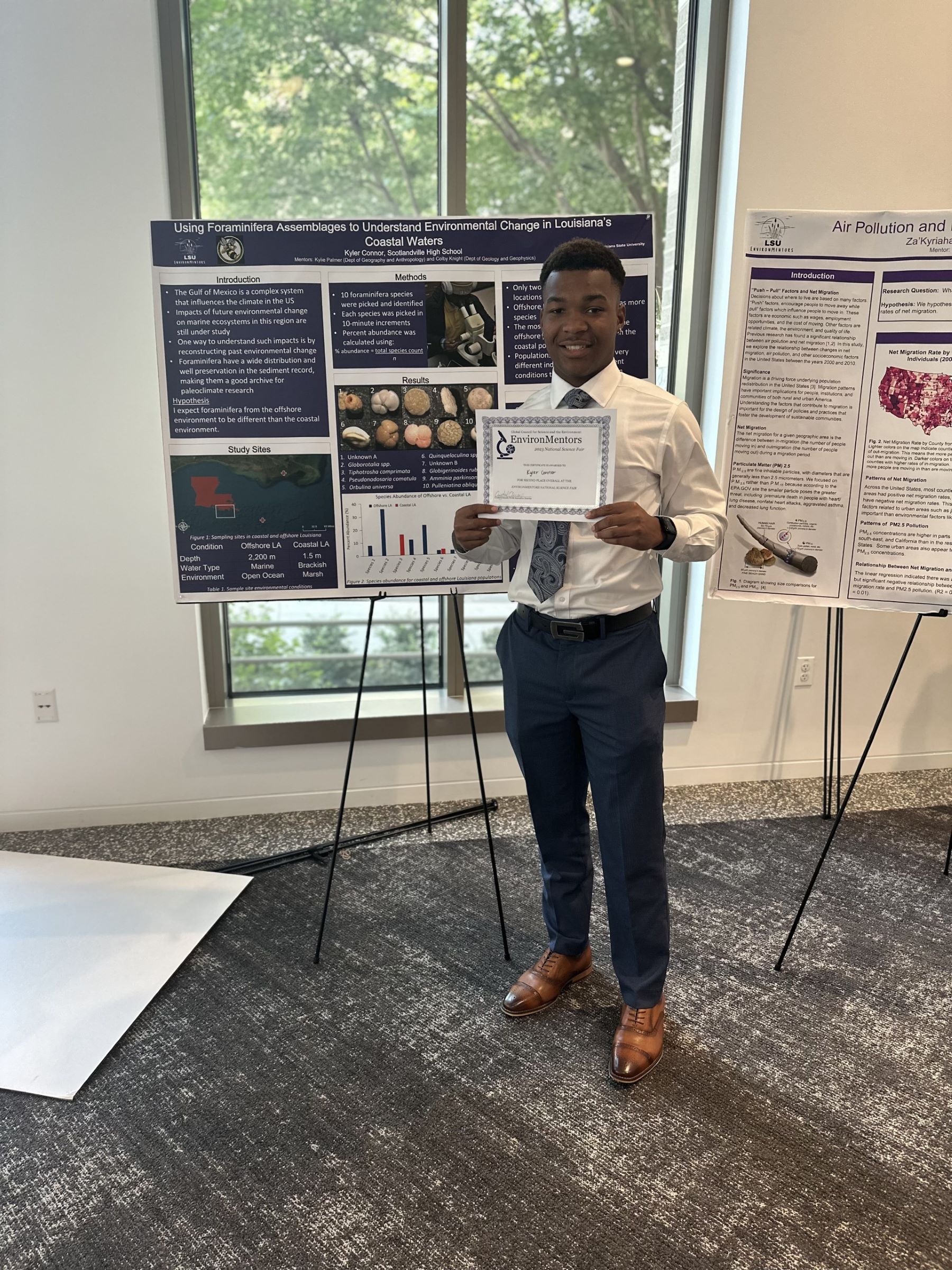 Kyler poses with his award in front of his research poster
