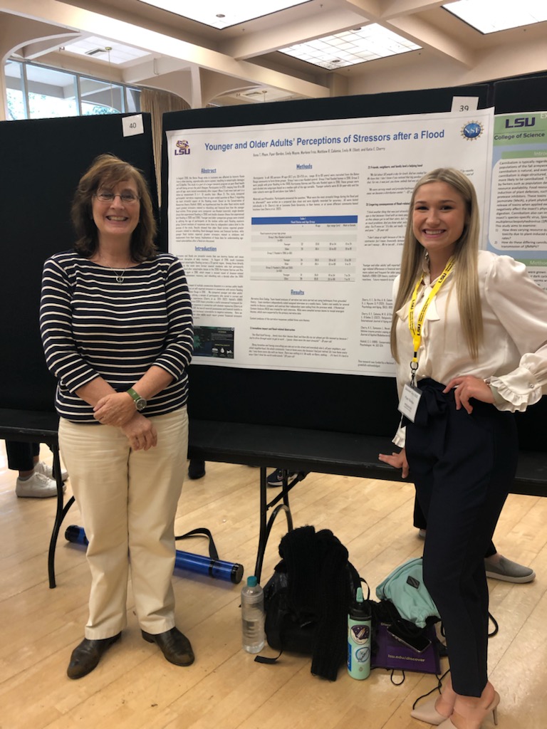 Dr. Katie Cherry and Piper Bordes standing in front of a poster