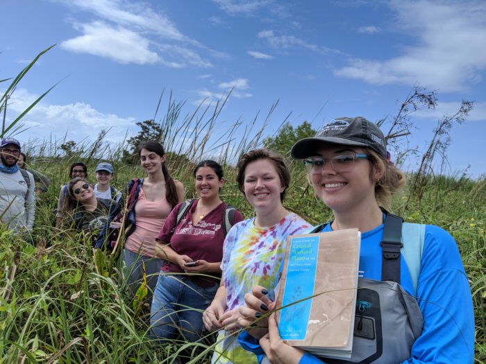 Students learning in a wetland with lots of invasive plants.