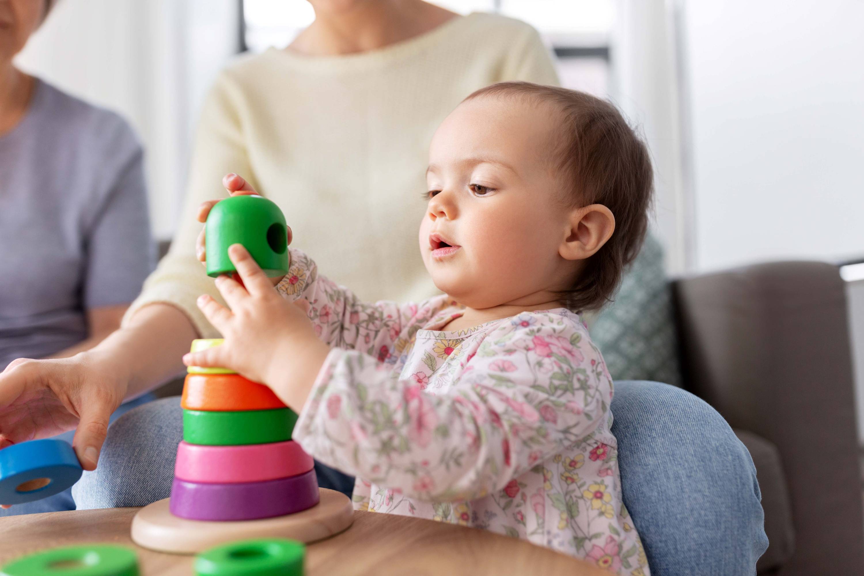 baby playing with stacking tower toys