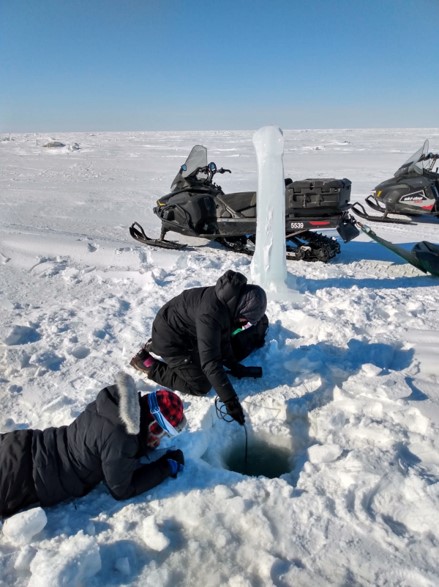 student in arctic measuring water quality