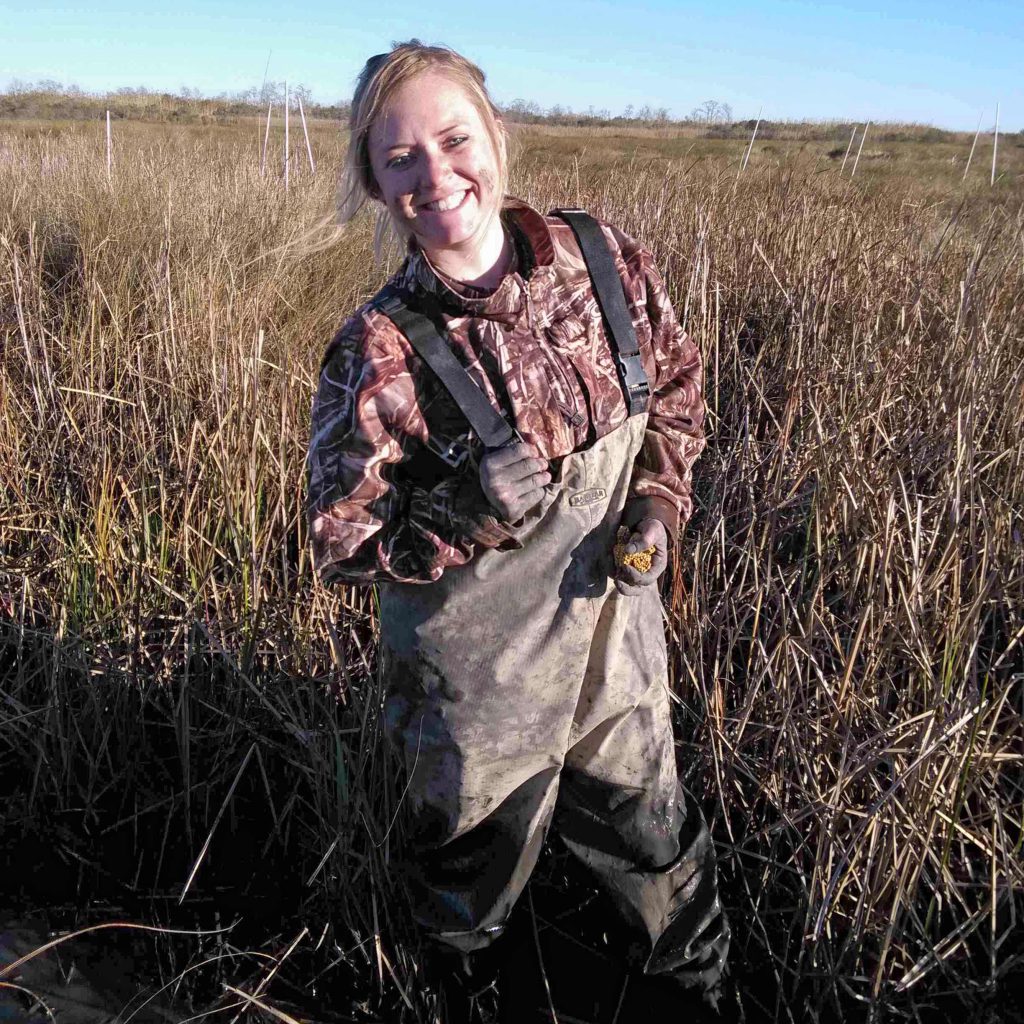Sarah Wood in waders in a marsh